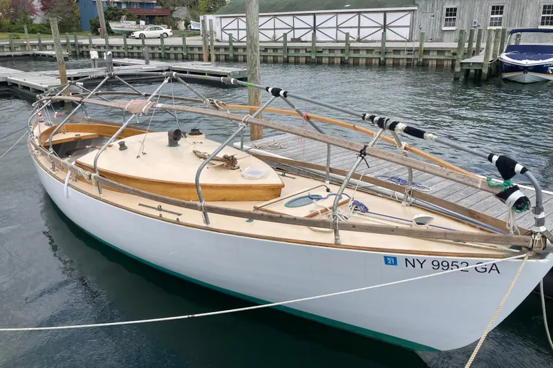 Slide: The Image of 1974 Herreshoff Rozinante sailboat docked, featuring classic wooden design and NY registration. - 60