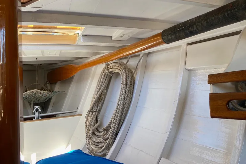 Slide: The Image of Interior of 1974 Herreshoff Rozinante sailboat with coiled rope and wooden details. - 75