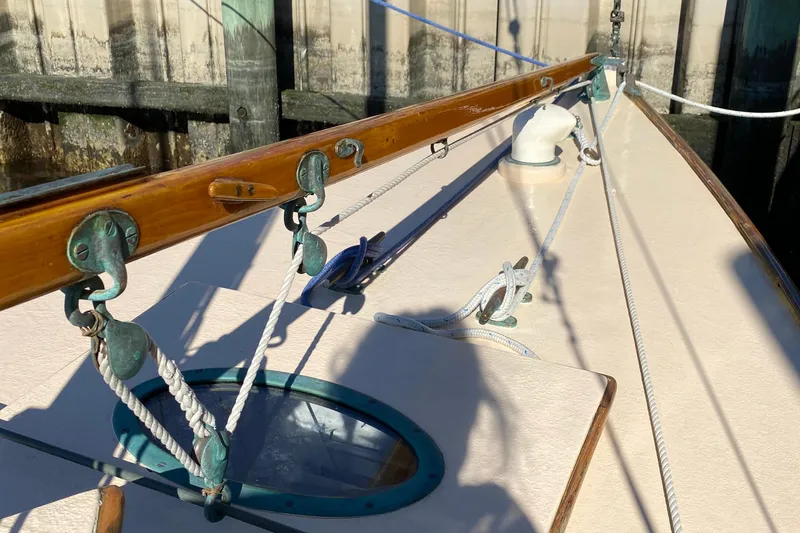 Slide: The Image of 1974 Herreshoff Rozinante sailboat deck with wooden details and rigging. - 32