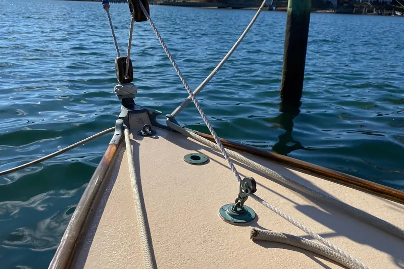 Slide: The Image of Bow of 1974 Herreshoff Rozinante sailboat on calm water. - 30