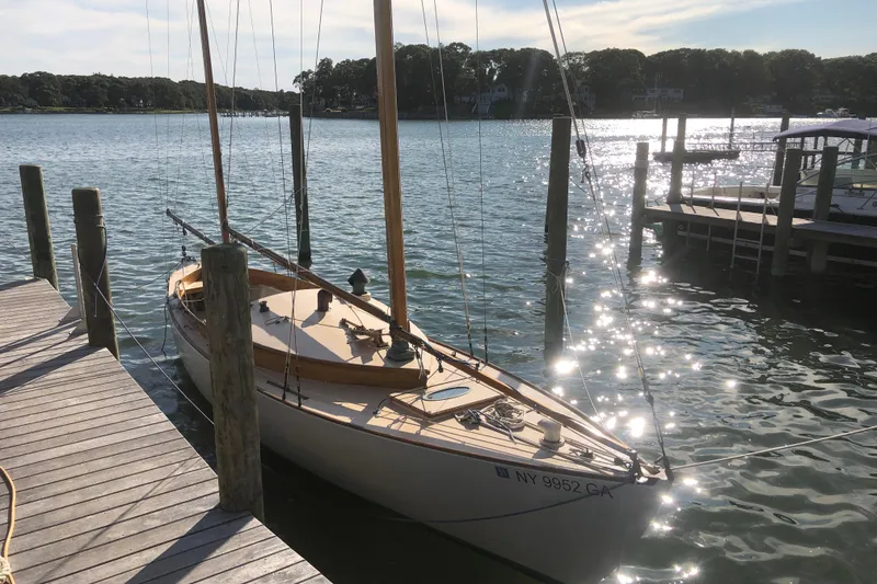 Slide: The Image of 1974 Herreshoff Rozinante sailboat docked on a sunny lake. - 15