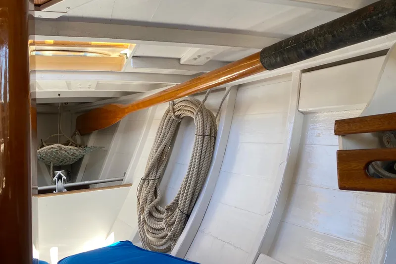 Slide: The Image of Interior of 1974 Herreshoff Rozinante sailboat with wooden details and coiled rope. - 38