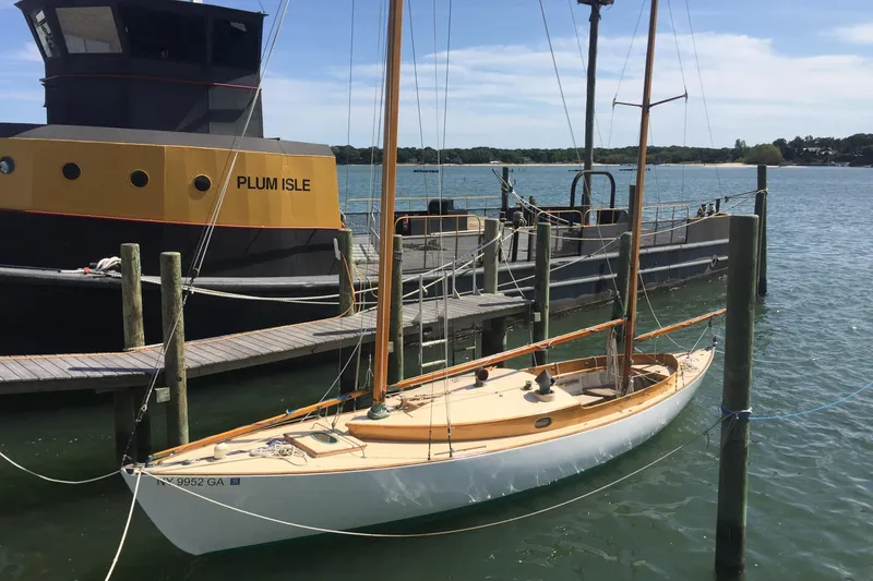 Slide: The Image of 1974 Herreshoff Rozinante sailboat docked beside a larger vessel named Plum Isle. - 12