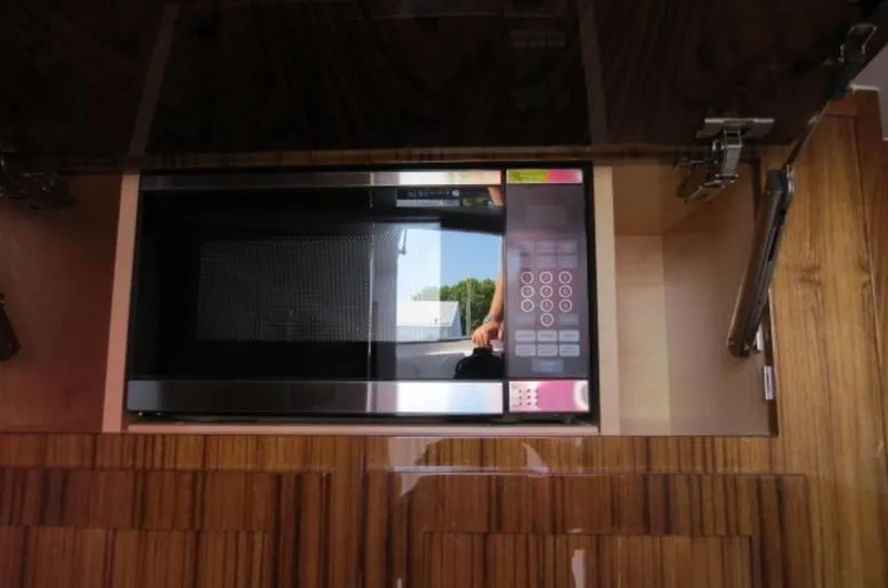 Slide: The Image of Microwave inside 2024 HCB 53 FT Suenos yacht kitchen with wooden cabinetry. - 29