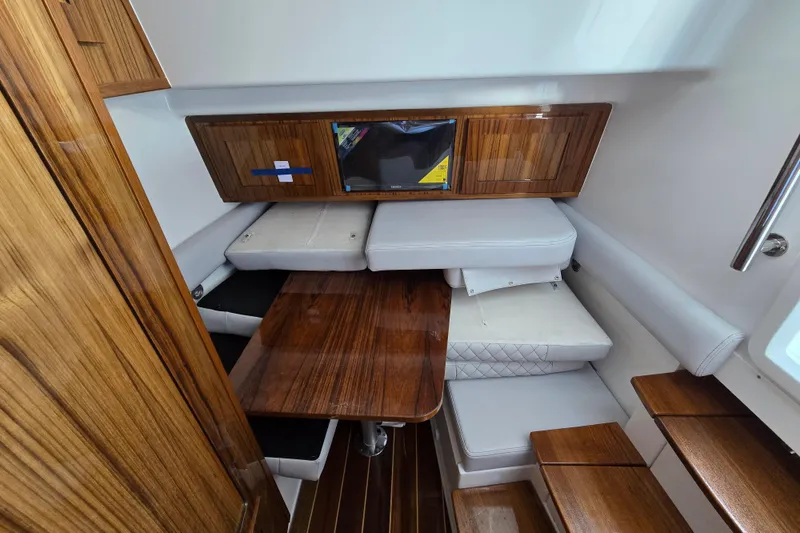 Slide: The Image of 2024 HCB 53 FT Suenos cabin interior with wooden finishes and white seating. - 40