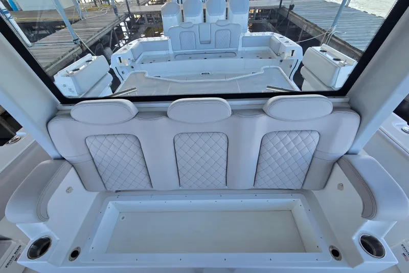 Slide: The Image of 2024 HCB 53 FT Suenos luxury boat interior with quilted seating and spacious deck. - 48