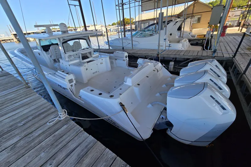 Slide: The Image of 2024 HCB 53 FT Suenos boat docked, featuring four powerful outboard engines. - 60