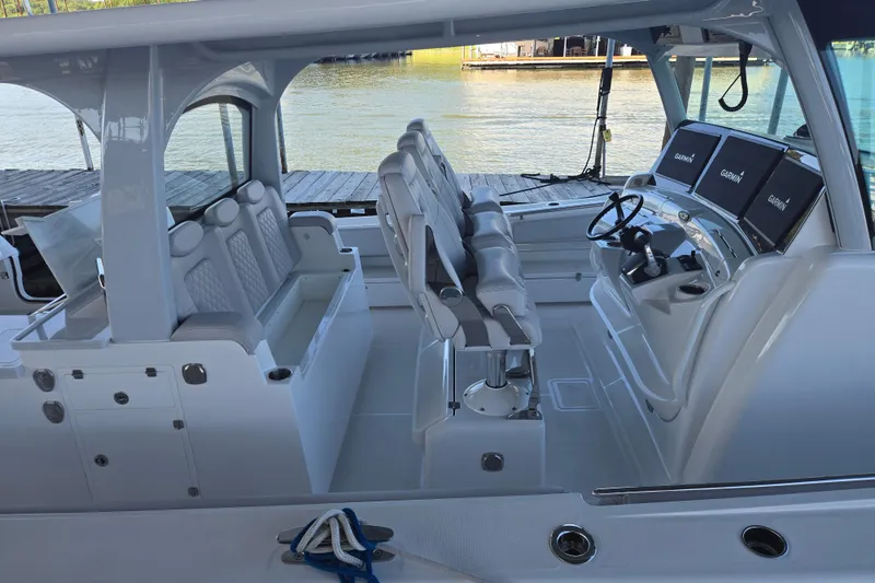 Slide: The Image of 2024 HCB 53 FT Suenos boat interior with helm, seating, and navigation screens. - 65