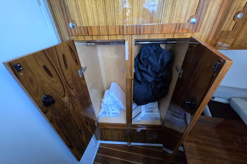 Slide: The Image of Wooden storage cabinets inside a 2024 HCB 53 FT Suenos boat, containing folded items. - 67