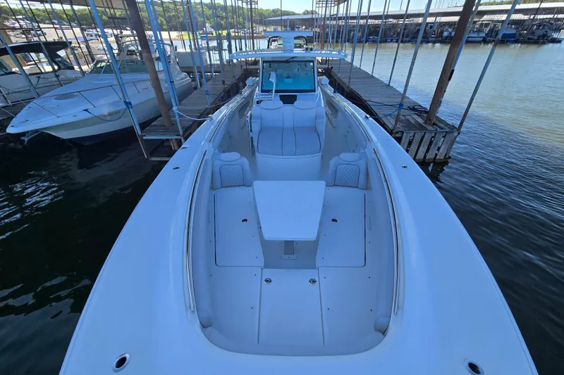 Slide: The Image of 2024 HCB 53 FT Suenos luxury boat docked at marina, showcasing spacious deck. - 69