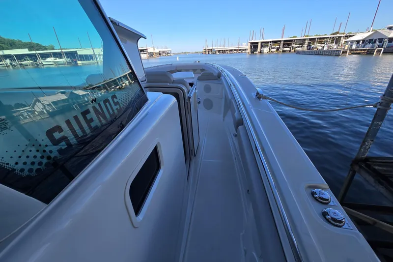 Slide: The Image of 2024 HCB 53 FT Suenos boat docked at a marina, showcasing sleek design and spacious deck. - 70