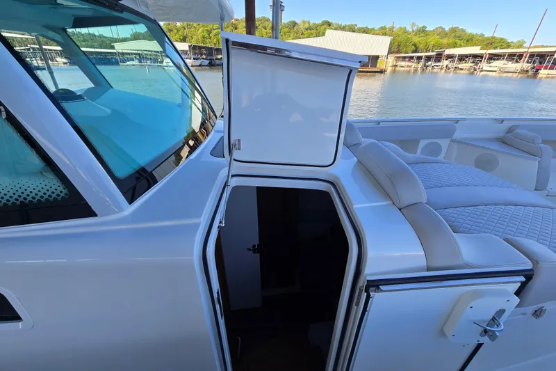 Slide: The Image of 2024 HCB 53 FT Suenos yacht with open cabin door, luxurious seating, and scenic marina view. - 71