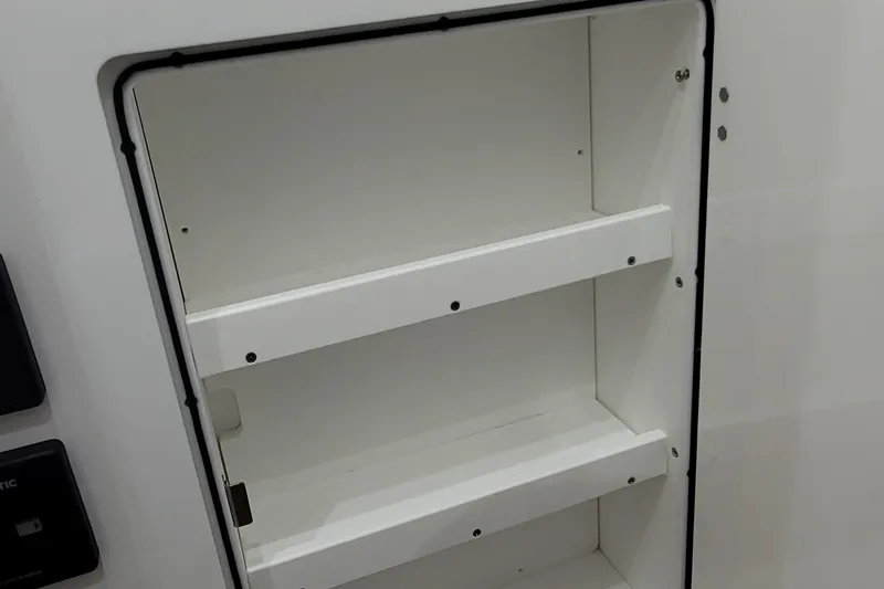 Slide: The Image of Storage compartment in 2023 HCB 39 FT Speciale boat, featuring white shelves. - 21