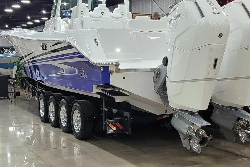 Slide: The Image of 2023 HCB 39 FT Speciale boat with dual outboard engines on display indoors. - 3