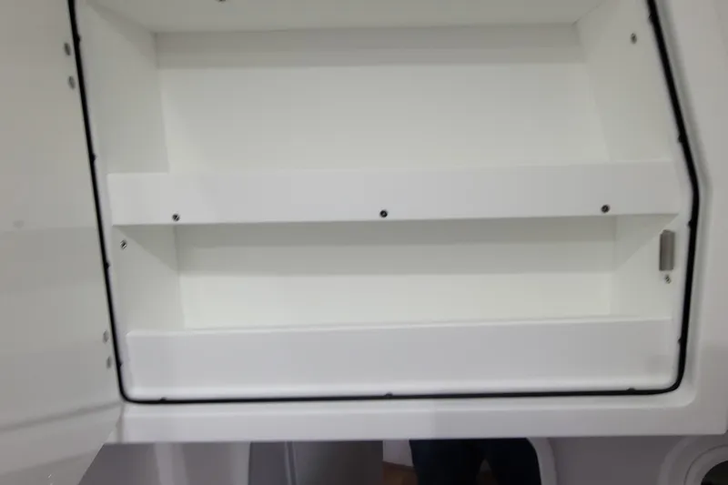 Slide: The Image of Open storage compartment on 2023 HCB 39 FT Speciale boat, featuring white interior shelves. - 32