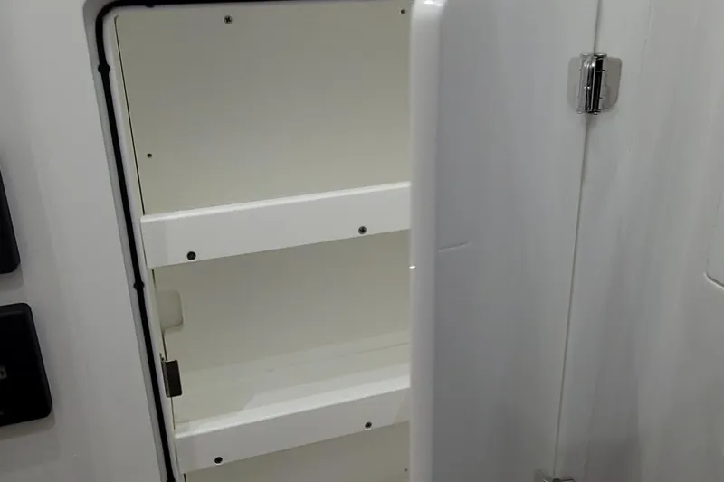 Slide: The Image of Open storage compartment on 2023 HCB 39 FT Speciale boat, featuring white shelves. - 57
