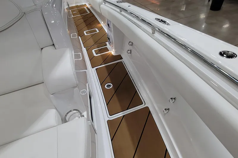 Slide: The Image of 2023 HCB 39 FT Speciale boat interior with sleek white seating and wood-accented flooring. - 61