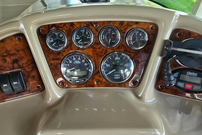 Slide: The Image of Dashboard of a 2004 Sea Ray 260 Sundancer boat with gauges and controls. - 11