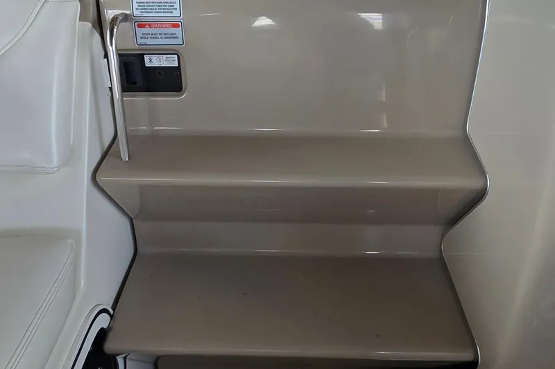 Slide: The Image of Staircase inside 2004 Sea Ray 260 Sundancer boat, featuring safety handle and warning labels. - 19