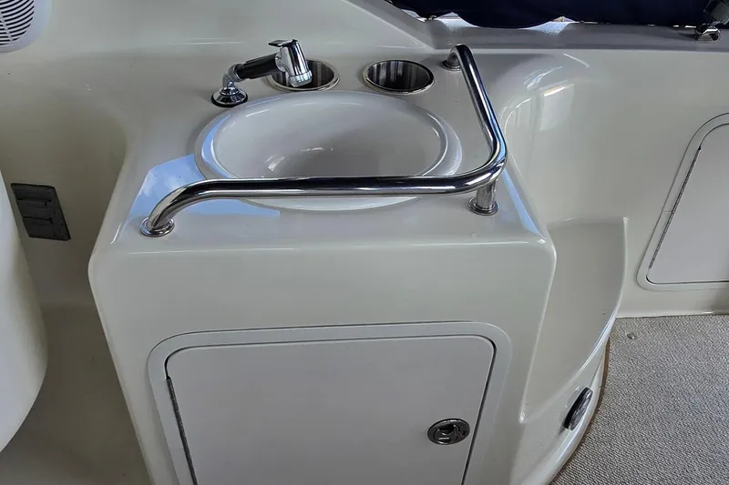 Slide: The Image of 2004 Sea Ray 260 Sundancer boat sink with faucet and storage compartment. - 20