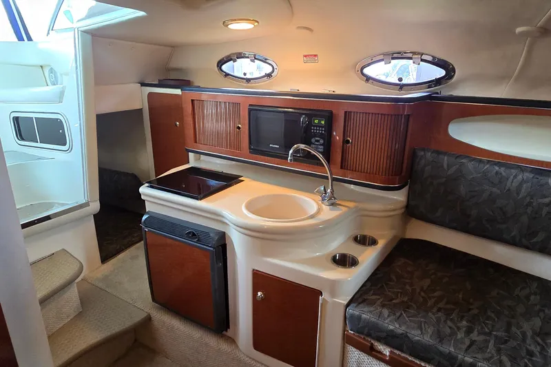 Slide: The Image of 2004 Sea Ray 260 Sundancer cabin interior with kitchenette and seating area. - 24