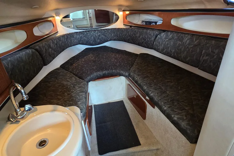 Slide: The Image of Interior cabin of a 2004 Sea Ray 260 Sundancer with cozy seating and a small sink. - 25