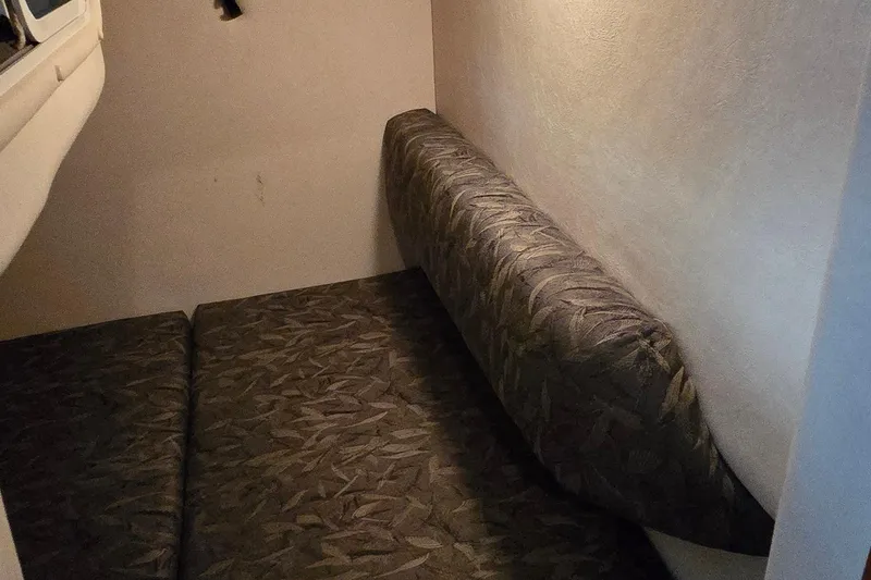 Slide: The Image of 2004 Sea Ray 260 Sundancer cabin interior with patterned cushions and compact design. - 29