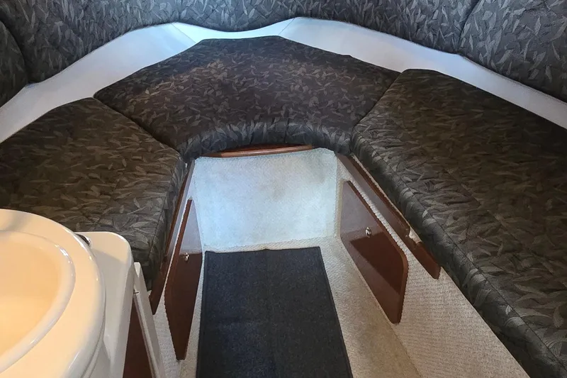 Slide: The Image of 2004 Sea Ray 260 Sundancer cabin interior with cushioned seating and storage compartments. - 32