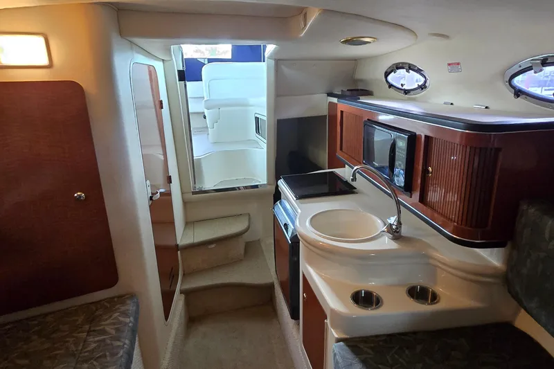 Slide: The Image of 2004 Sea Ray 260 Sundancer cabin interior with kitchenette and seating area. - 33
