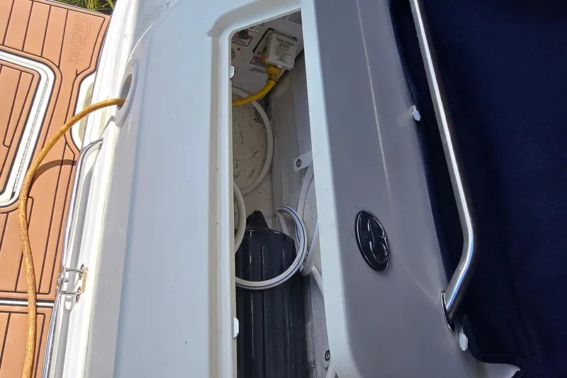 Slide: The Image of Open storage compartment on 2004 Sea Ray 260 Sundancer boat with visible cables and equipment. - 36