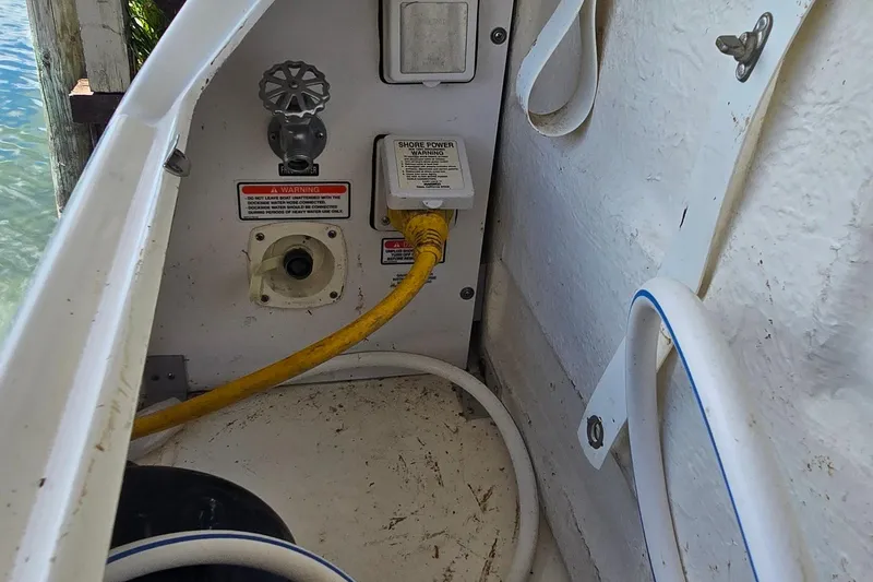 Slide: The Image of 2004 Sea Ray 260 Sundancer shore power connection with yellow cable and warning labels. - 37
