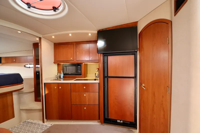 Slide: The Image of Interior of 2000 Cruisers Yachts 3870 with kitchen and wooden cabinets. - 2