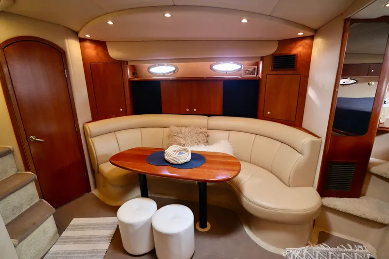 Slide: The Image of Interior of a 2000 Cruisers Yachts 3870 with leather sofa and wooden table. - 4