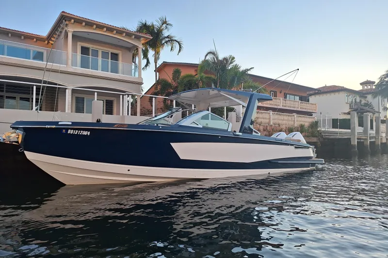 The Image of 2021 Aviara AV32 OB boat docked near waterfront homes, surrounded by palm trees. - 0