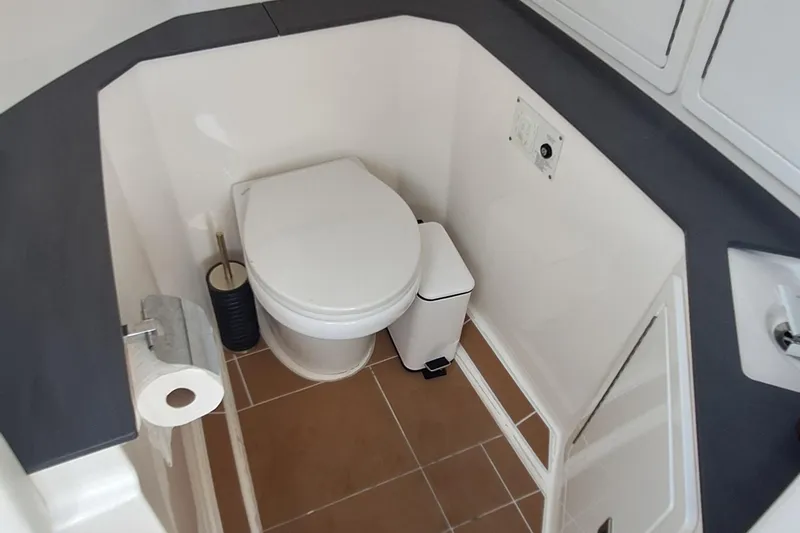 Slide: The Image of 2021 Aviara AV32 OB boat bathroom with toilet, sink, and storage cabinets. - 23