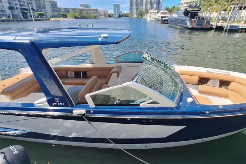 Slide: The Image of 2021 Aviara AV32 OB boat docked in a marina, featuring sleek design and spacious seating. - 5