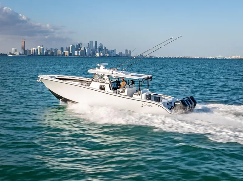 Slide: The Image of 2024 Yellowfin 42 boat cruising on open water with city skyline in background. - 12