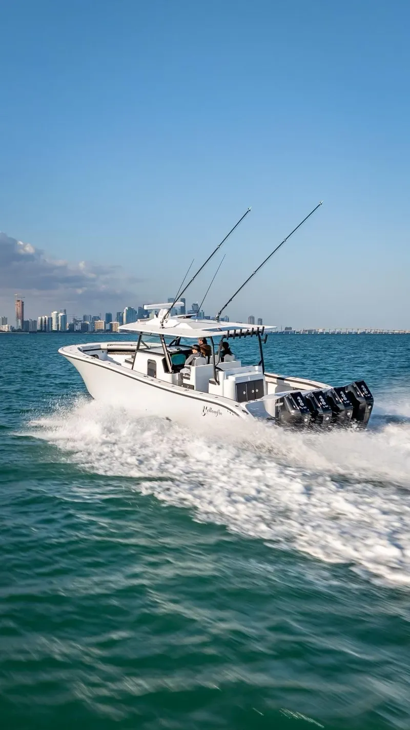 Slide: The Image of 2024 Yellowfin 42 boat cruising on open water with city skyline in background. - 13