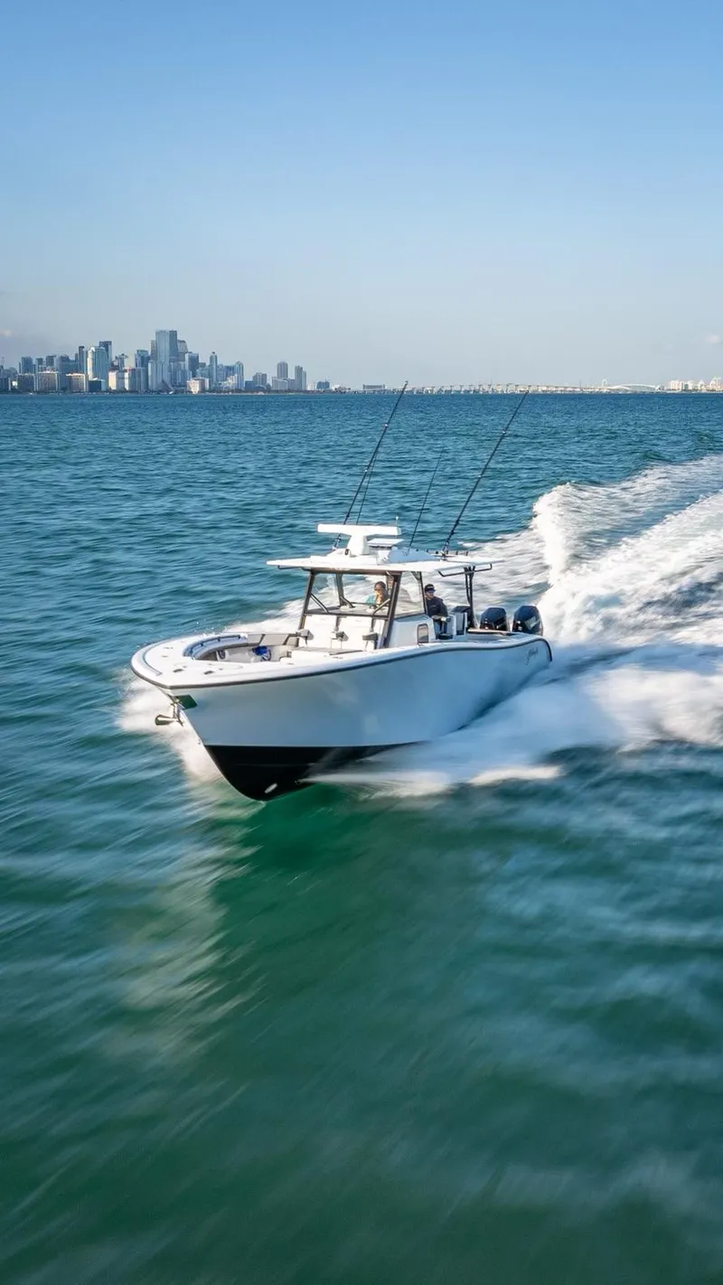 Slide: The Image of 2024 Yellowfin 42 boat cruising on open water near city skyline. - 4