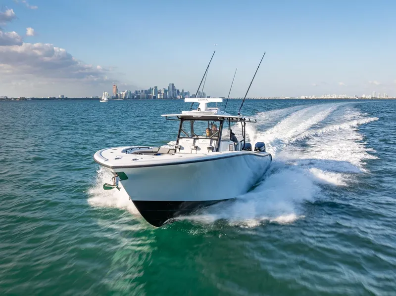 Slide: The Image of 2024 Yellowfin 42 boat cruising on open water with city skyline in background. - 7