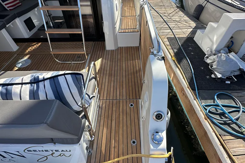 Slide: The Image of 2023 Beneteau Antares 11 Fly boat deck with wooden flooring and seating area. - 10