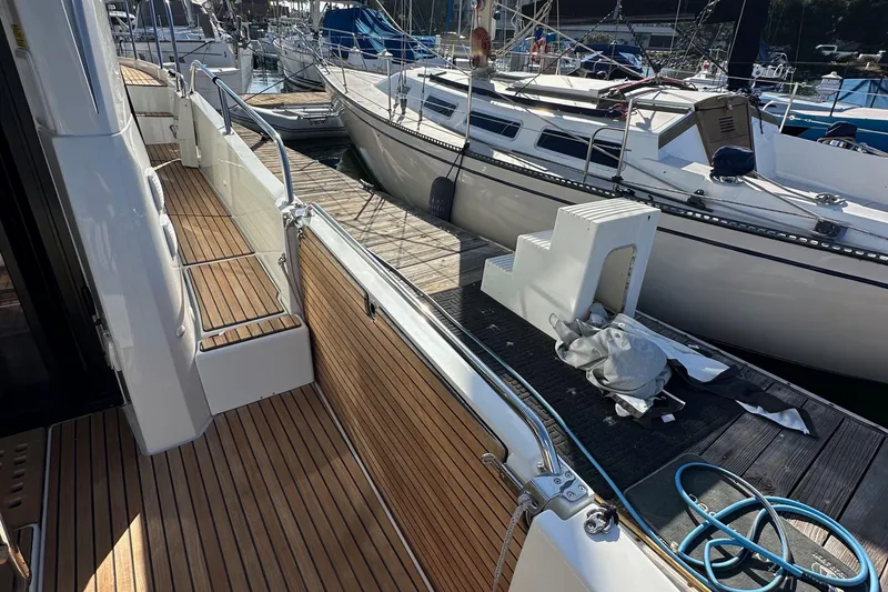 Slide: The Image of 2023 Beneteau Antares 11 Fly yacht docked, showcasing sleek deck design and marina surroundings. - 12
