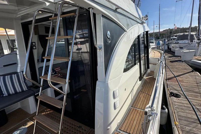 Slide: The Image of 2023 Beneteau Antares 11 Fly yacht with sleek design and wooden deck at marina. - 14