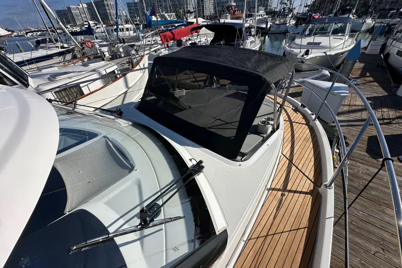Slide: The Image of 2023 Beneteau Antares 11 Fly yacht docked at marina, showcasing sleek design and wooden deck. - 17
