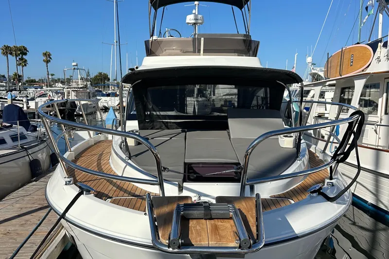Slide: The Image of 2023 Beneteau Antares 11 Fly yacht docked at marina, showcasing sleek design and spacious deck. - 2