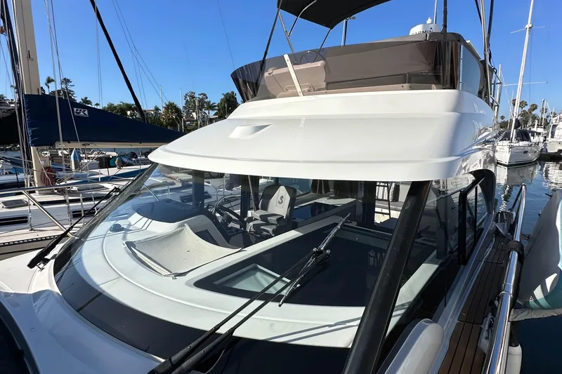 Slide: The Image of 2023 Beneteau Antares 11 Fly yacht docked at marina, showcasing sleek design and flybridge. - 24