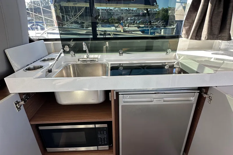 Slide: The Image of Modern kitchen area in 2023 Beneteau Antares 11 Fly yacht with sink, stove, and microwave. - 35