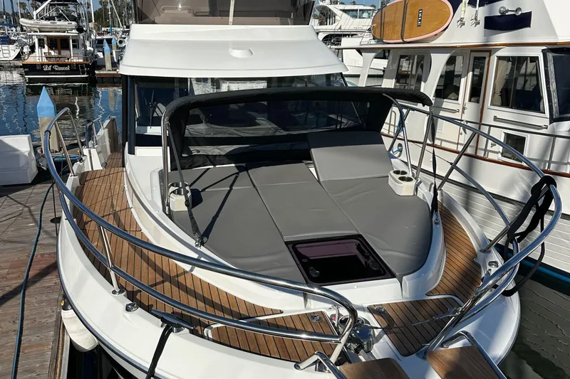 Slide: The Image of 2023 Beneteau Antares 11 Fly yacht with sunbathing area, docked at marina. - 4