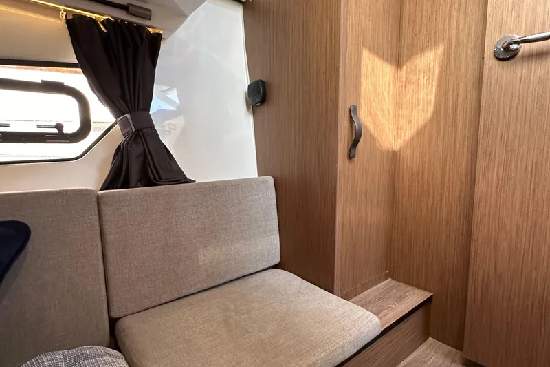 Slide: The Image of Interior of 2023 Beneteau Antares 11 Fly, featuring cozy seating and wooden cabinetry. - 50