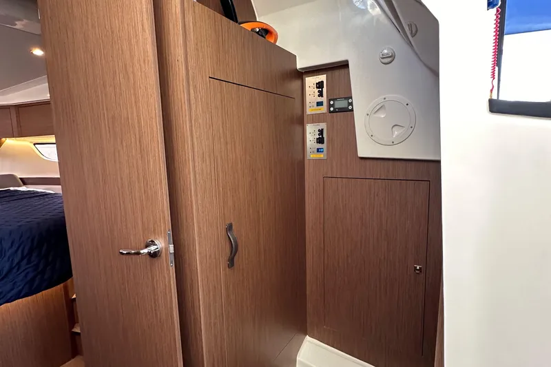 Slide: The Image of Interior of 2023 Beneteau Antares 11 Fly, featuring wood paneling and cabin access. - 51